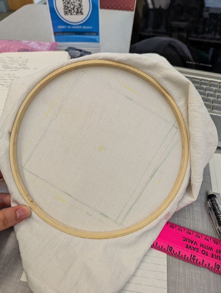 white fabric in an embroidery hoop with a square traced in pencil