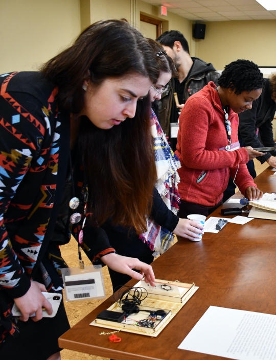 People looking at objects at the Bibliocircuitry: Old Books, New Stories showcase